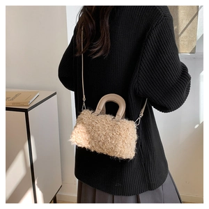 Close-up of beige fleece crossbody bag with leather handles and silver metal hardware