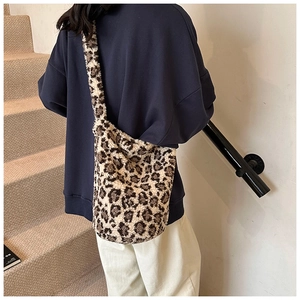 Detail shot of plush leopard print bucket bag with wide faux fur shoulder strap