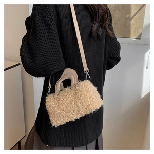 Detail of plush faux shearling handbag showing curly texture and crossbody strap