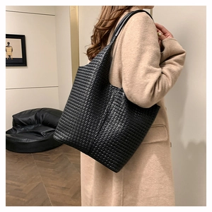 Détail de la texture tissée du grand sac fourre-tout noir et de sa fine bandoulière