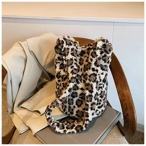Detail of leopard print plush bucket bag with soft faux fur texture and wide shoulder strap