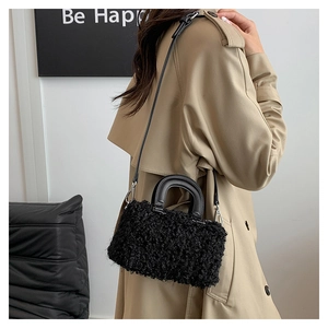 Model view of black fleece box bag with smooth leather handle and silver metal hardware