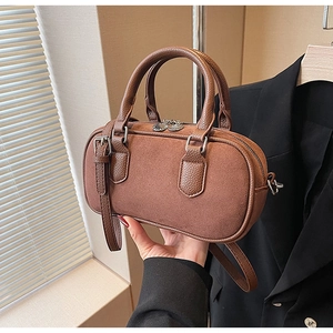 Detail der braunen Boston-Tasche aus Wildleder mit Ledergriffen und Silber-Zippern