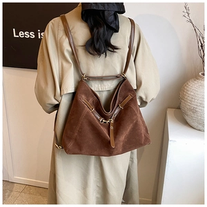 Rear view of model wearing a vintage dark brown suede tote backpack with leather straps