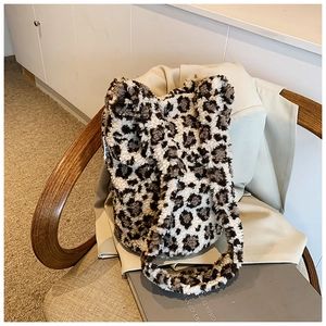 Close-up of leopard print plush tote bag on a blazer and wooden chair setup