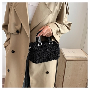 Detail of black fluffy faux fur handbag with leather handle and silver hardware