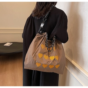 Brown nylon tote bag with yellow heart embroidery and black white braided rope handle