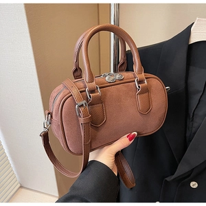 Detail der karamellfarbenen Zylindertasche aus Leder mit Lychee-Maserung und Matt-Samt