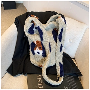Detail of plush bucket bag featuring abstract dog patterns on a beige armchair with books