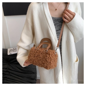 Close-up of brown faux fur crossbody bag with leather handles and silver hardware