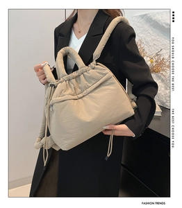 Detail of beige quilted nylon backpack with soft padded handles and drawstring side design