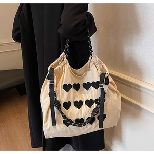 Detailed view of large off-white embroidered tote bag with heart patches and rope handles