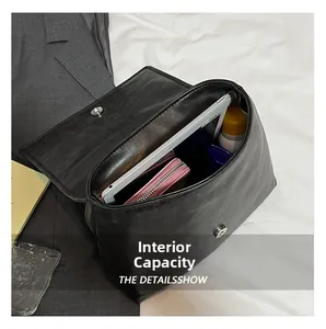Detail view of the black leather backpack showing spacious internal capacity and storage