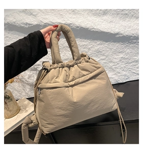 Detail of khaki quilted tote bag featuring drawstring closures and padded handles