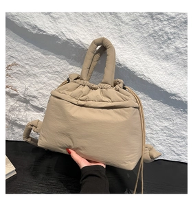 Detail of khaki quilted puffer tote bag featuring drawstring closure and padded handles