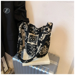 Detail of plush black and white faux shearling tote bag with vintage patterns and MISS tag