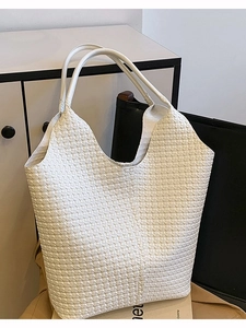 Grand sac cabas tressé blanc au style minimaliste présenté dans un décor intérieur