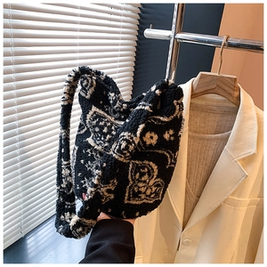Detailed shot of plush black and white heart pattern faux shearling shoulder bag