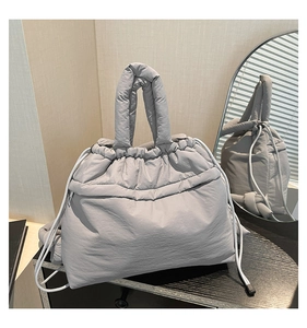 Detail view of large grey quilted nylon tote bag with soft padded texture and drawstring