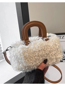 Chic white faux shearling box bag with brown leather handles and a silver metal clasp