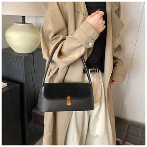 Detail of black matte suede and smooth leather shoulder bag with gold metal buckle