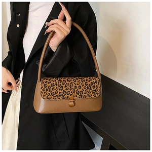 Detail of vintage leopard print flap and metallic buckle on brown matte shoulder bag