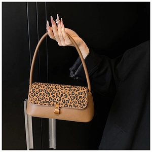 Detail of vintage leopard print flap and gold metal clasp on a brown shoulder bag