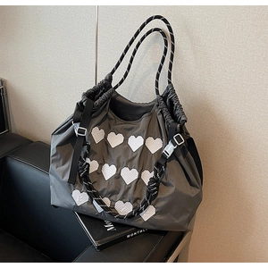 Detail of grey embroidered heart tote bag with drawstring closure and rope handles