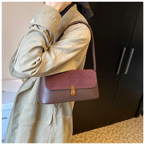 Detail of vintage purple suede and leather patchwork underarm bag with gold buckle