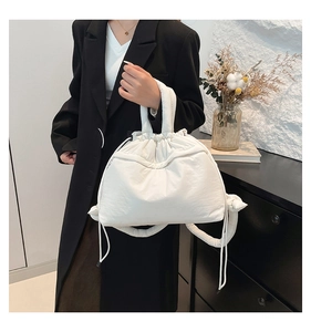 Detail of white quilted puffer handbag with drawstring and nylon cloud texture