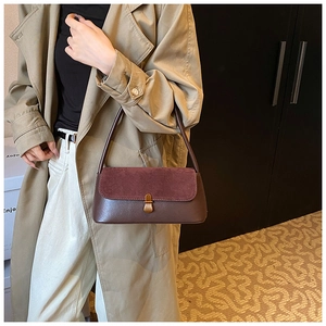 Detailed view of vintage shoulder bag with textured suede flap and gold buckle on khaki coat