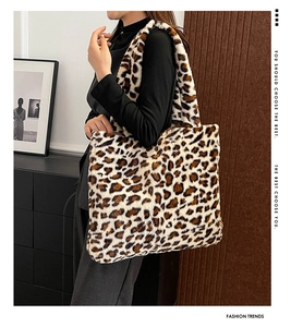 Borsa tote in ecopelliccia leopardata indossata da una modella in una stanza minimalista
