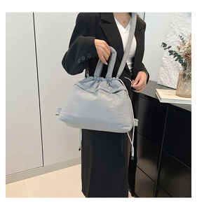 Detail of light gray puffy cloud tote bag featuring drawstring closure and nylon fabric