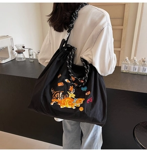 Detail der süßen Katzenstickerei auf schwarzem Canvas-Shopper mit zweifarbigem Seilgriff