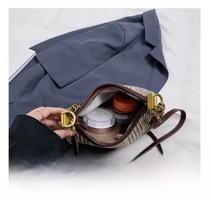 Detail shot of plaid shoulder bag interior capacity showing cosmetics and lining