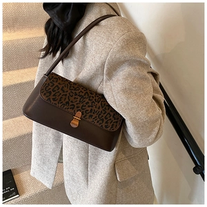 Detail of vintage leopard print shoulder bag with gold metal buckle and leather strap