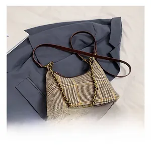 Detail of the vintage plaid fabric texture and dark brown leather trim on the chain shoulder bag
