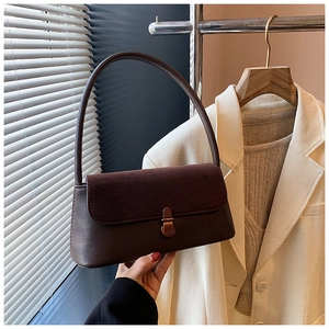 Detailed view of the dark brown matte leather flap and metal twist lock on the handbag