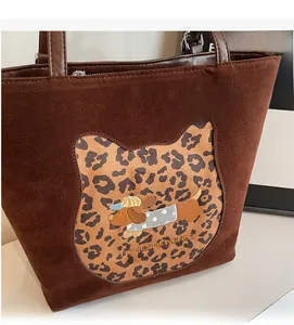 Detail of brown suede tote bag with leopard print panel and cute puppy embroidery