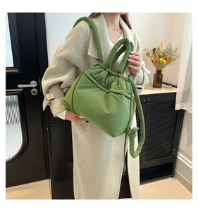 Close-up of green padded puffer tote bag with drawstring closure and soft handles