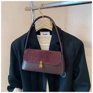 Close-up of vintage underarm bag with dark brown leather and burgundy suede texture