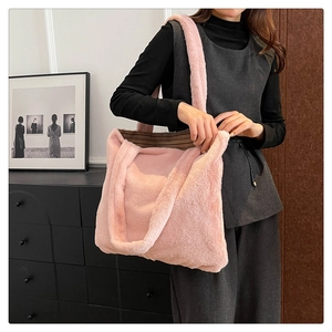Dettaglio della borsa tote in pelliccia sintetica rosa con texture morbida e manici a righe