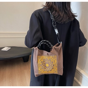 Nahaufnahme der braunen Segeltuch-Tasche mit Paisley-Stickerei und Kordelzuggriff