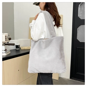 Grande borsa tote in finta pelliccia grigio chiaro indossata da una modella per l'inverno