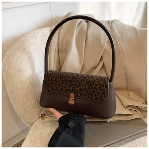 Close-up of vintage leopard print handbag with leather trim and gold metal clasp detail