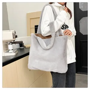 Dettaglio della borsa tote in peluche grigio maculato indossata da una modella in un caffè