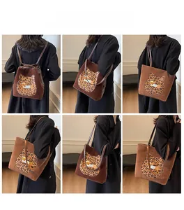 Brown suede tote showing versatile shoulder and backpack carrying styles with cat motif