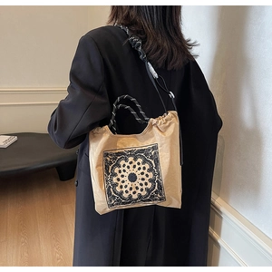 Detail der Vintage-Tasche mit Paisley-Muster in Hellbeige und gewebten Seilgriffen