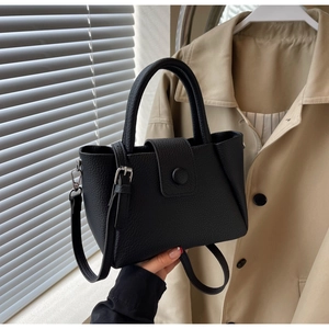 Gros plan du sac seau noir en cuir grainé avec détails métalliques argentés élégants