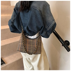 Detail of retro houndstooth hobo bag with gold chain strap and chic crossbody style